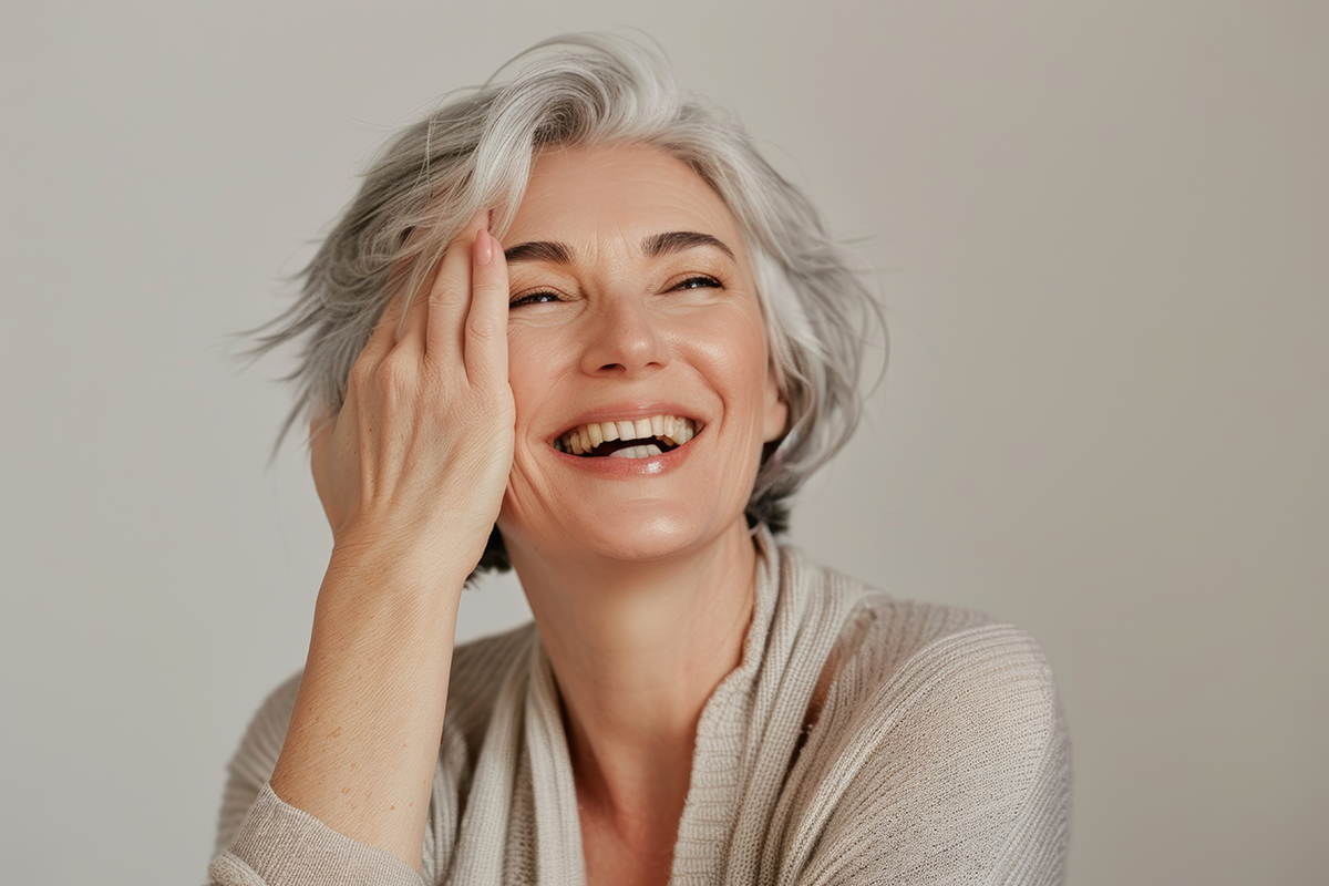Beautiful face and smiling mature woman with shining anti-aging cosmetics and dermatology