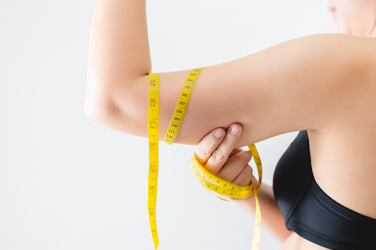 Close up of a woman grabbing upper arm with excess fat