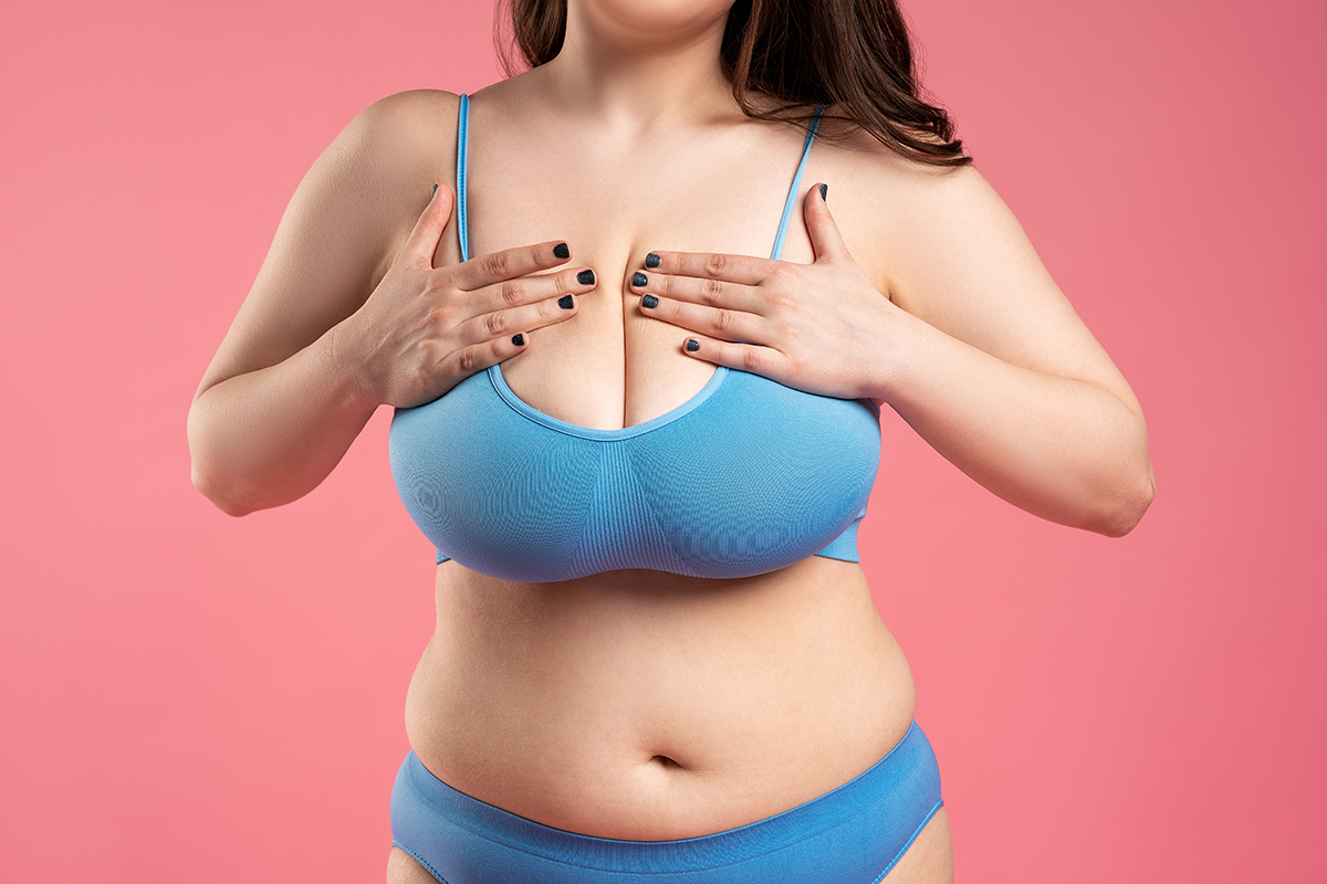 Woman checking her very large breasts for cancer